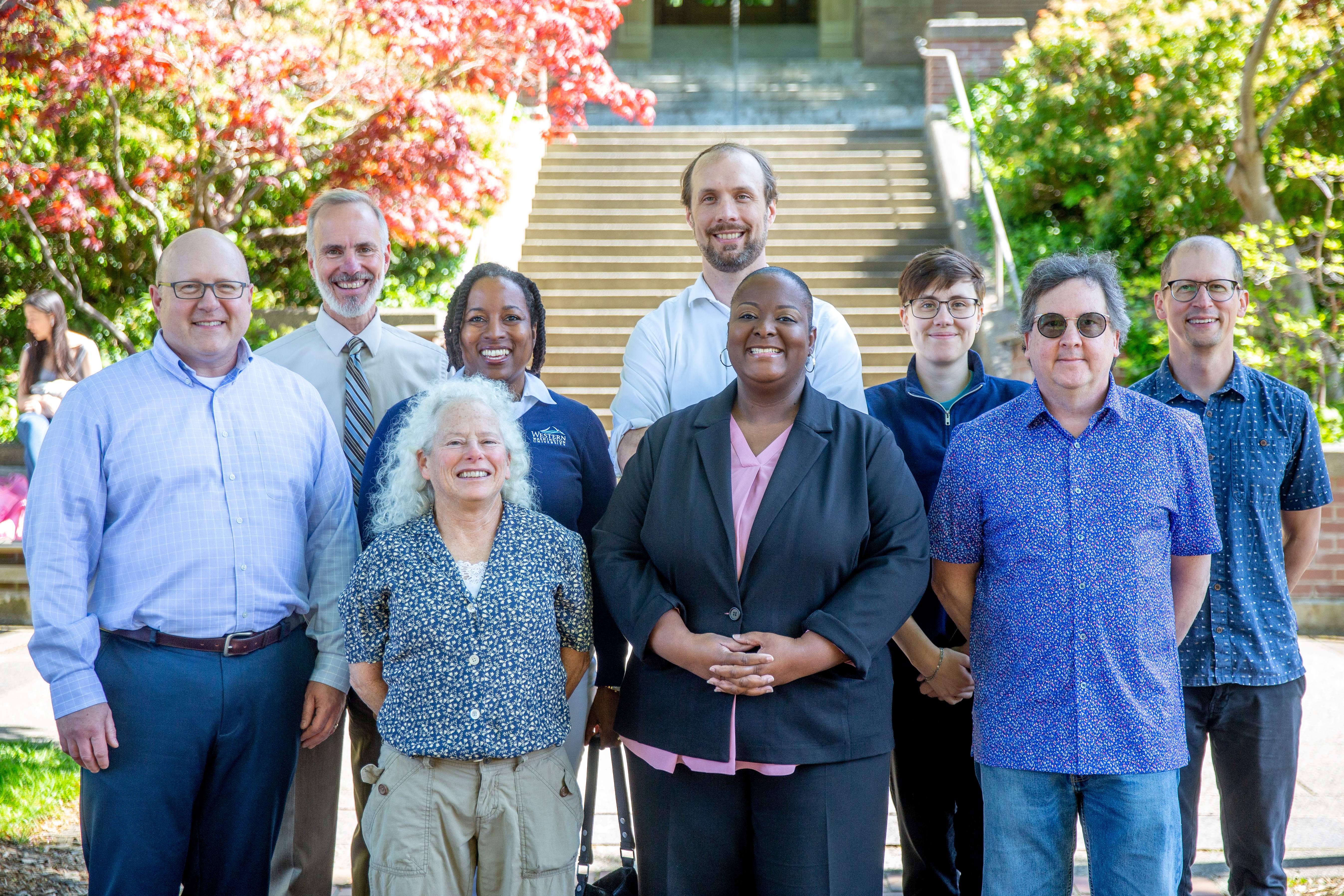 Group photo of nine of the Leadership Philanthropy to Geology Team members smiling in front of the Old Main steps