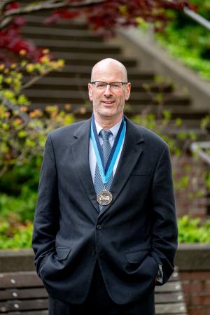 Scott Wilkinson wearing WWU award medallion