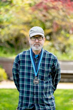 Jeff Osthimer wearing a WWU award medallion