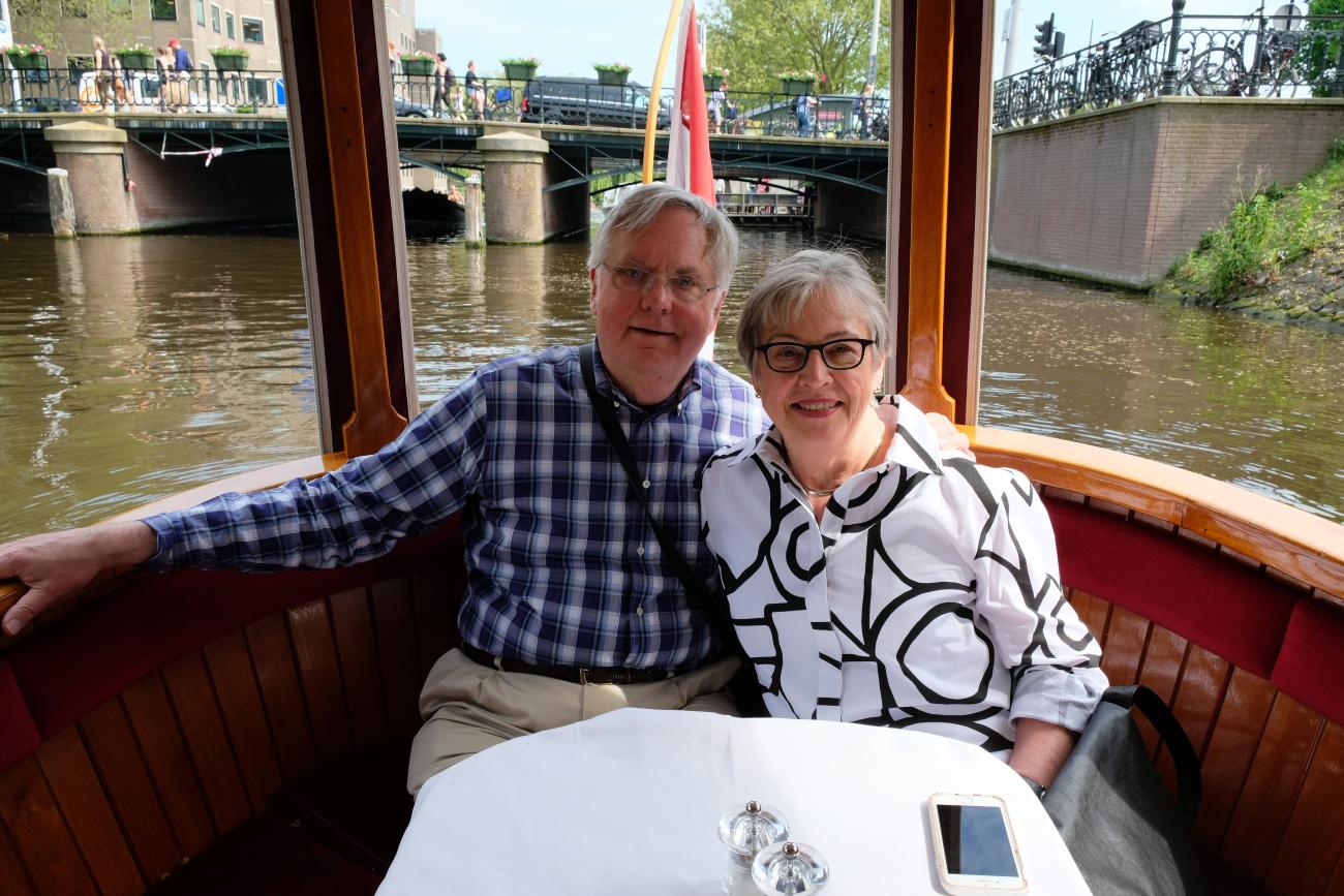 John and Laurel Nesholm sit at a table in a boat