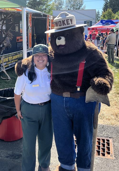Jennifer Santos Morales poses with Smokey Bear at a community event