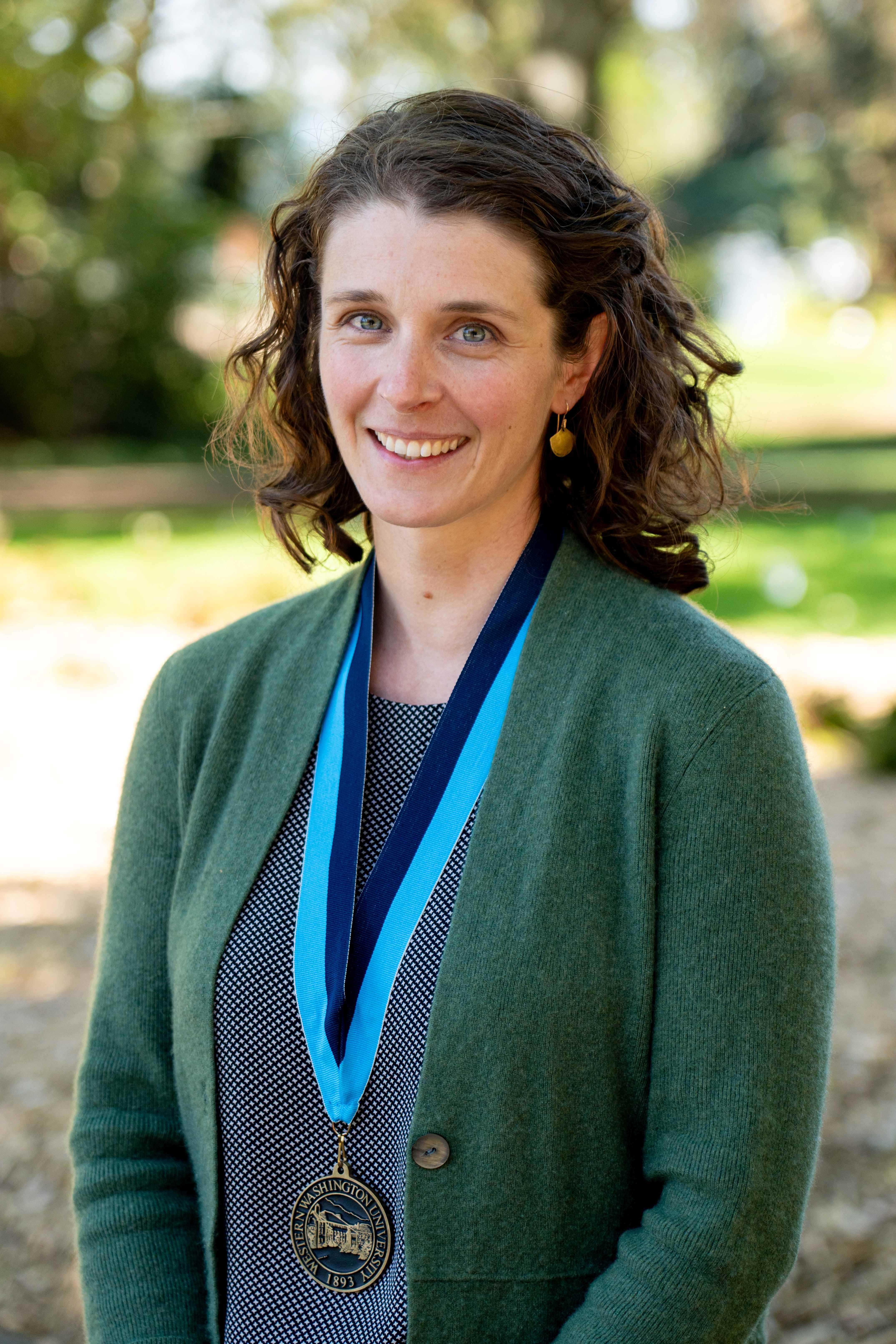 Dr. Allison Pfeiffer wearing a soft green cardigan and the WWU award medallion